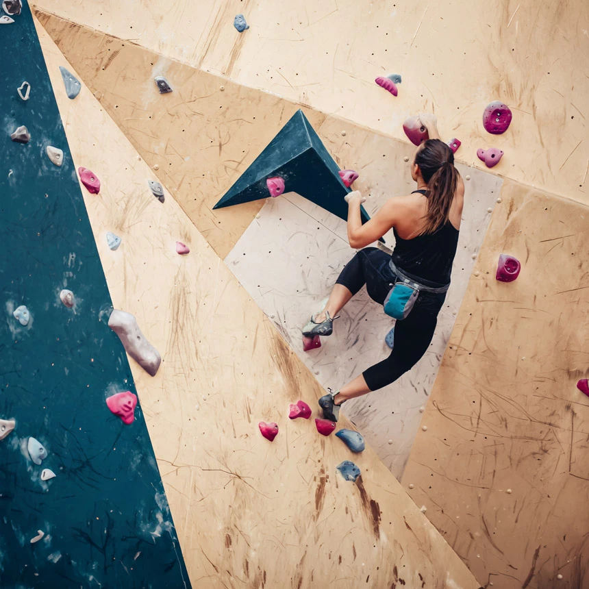 Climber on colorful holds of an indoor climbing wall