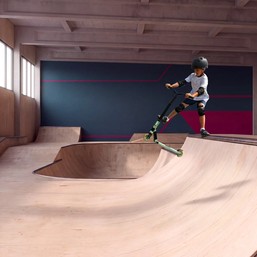Helmeted scooter rider doing a trick in the air above an indoor ramp