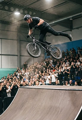 BMX rider jumping in front of a crowd